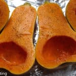 Butternut Squash halves lying on foil.