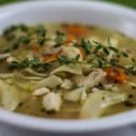 White bowl filled with chicken noodle soup.